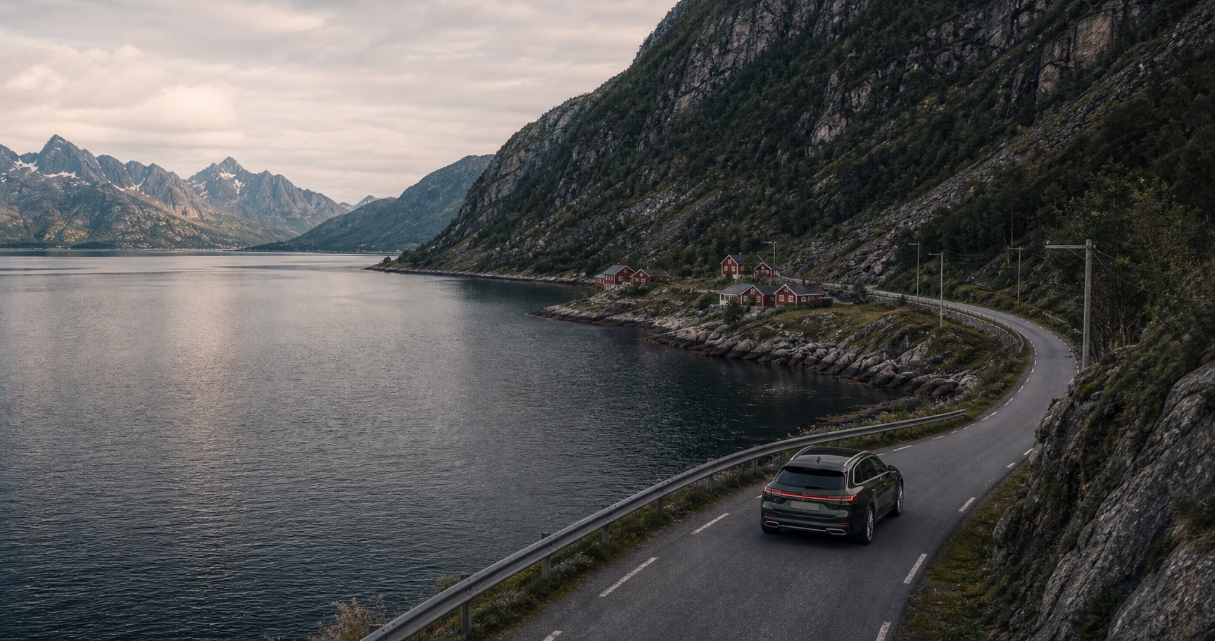 A modern car on a road beside a Nordic fjord.